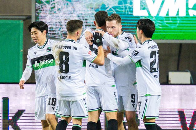 05.12.2025 - Fußball, 2025 2026, 2. Bundesliga, 15. Spieltag, SC Preußen Münster - Hannover 96: (2R) Benjamin Källman (Hannover) jubelt nach seinem Tor zum 0:1 in einer Jubeltraube mit (L-R) Daisuke Yokota (Hannover), Enzo Leopold (Hannover), Virgil GhiÈ›a (Hannover), Hayate Matsuda (Hannover) DFL REGULATIONS PROHIBIT ANY USE OF PHOTOGRAPHS AS IMAGE SEQUENCES AND OR QUASI-VIDEO.