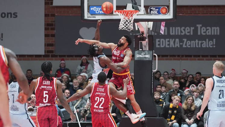 Im Bild: v.li. Brian Fobbs (EWE Baskets Oldenburg) wird von David Muenkat (Wuerzburg Baskets, 55) geblockt 05.12.2025, Basketball, Fitness First Wuerzburg Baskets vs. EWE Baskets Oldenburg, easyCredit BBL, 9. Spieltag, Deutschland, Wuerzburg, tectake-Arena, Copyright: HMBxMedia xPeterxRau