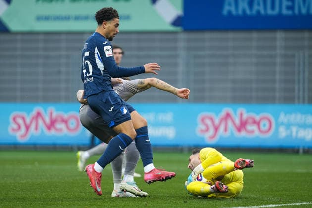 Fussball: 3. Liga, 17. Spieltag, TSG Hoffenheim II - Jahn Regensburg am 06.12.2025 in Sinsheim (Dietmar-Hopp-Stadion), Deutschland, Saison 2025 2026: DFB DFL REGULATIONS PROHIBIT ANY USE OF PHOTOGRAPHS as IMAGE SEQUENCES and or QUASI-VIDEO: Felix Gebhardt (1, SSV) vor Ben Opoku Labes (45, TSGII) am Ball. Sinsheim Dietmar-Hopp-Stadion Deutschland Copyright: xChristophxKinzingerx