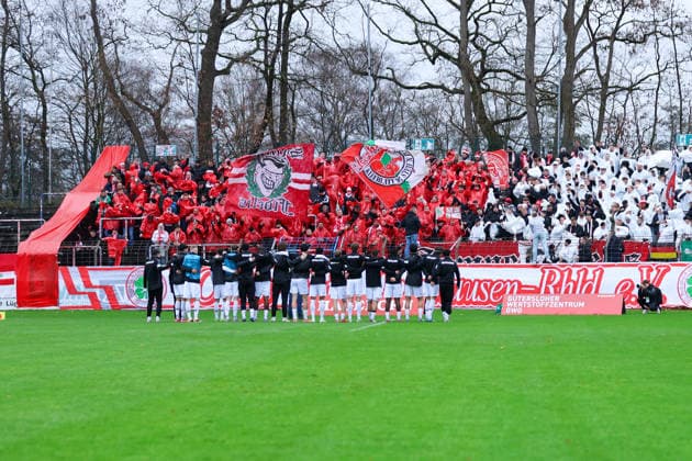 06.12.2025, xKWIx, Fußball, Regionalliga West, FC Gütersloh - RW Oberhausen, Ohlendorf Stadion im Heidewald: Oberhausen Fans im Block mit Choreo und den Spielern Arm in Arm vor dem Block Photo: xKamilxWilkowskixPressefotoKochx NRW Deutschland