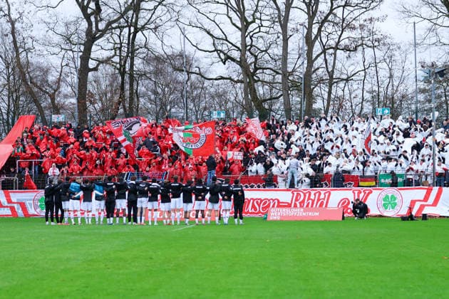 06.12.2025, xKWIx, Fußball, Regionalliga West, FC Gütersloh - RW Oberhausen, Ohlendorf Stadion im Heidewald: Oberhausen Fans im Block mit Choreo und den Spielern Arm in Arm vor dem Block Photo: xKamilxWilkowskixPressefotoKochx NRW Deutschland
