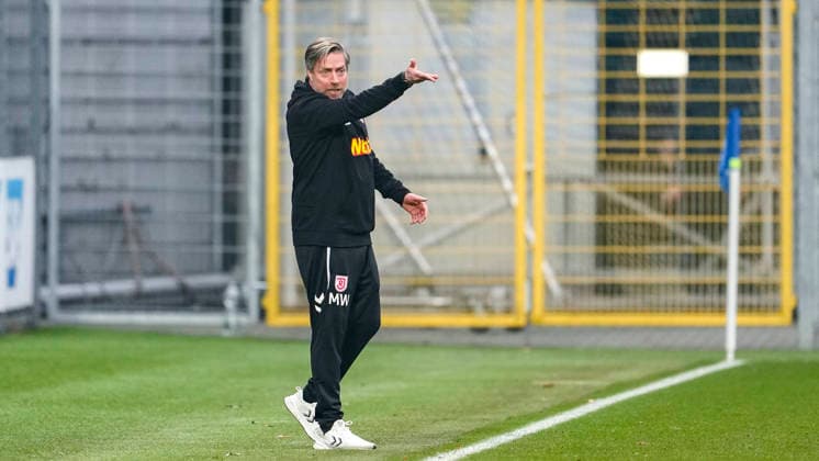 Michael Wimmer (Trainer, Cheftrainer, Regensburg), gibt Anweisungen, gestikuliert, mit den Armen gestikulieren, Freisteller, Ganzkörper, Einzelbild, Einzelfoto, Aktion, Action, am Spielfeldrand, an der Seitenauslinie, 06.12.2025, Sinsheim (Deutschland), Fussball, 3. Liga, TSG 1899 Hoffenheim II - SSV Jahn Regensburg, DFB DFL REGULATIONS PROHIBIT ANY USE OF PHOTOGRAPHS AS IMAGE SEQUENCES AND OR QUASI-VIDEO.