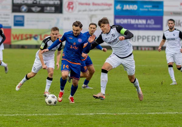 Zweikampf zwischen: Maximilian Hippe (SV Roedinghausen, 5) und Oemer Tokac (Sportfreunde Siegen, 14) SV Rödinghausen - Sportfreunde Siegen 28.11.2025 Fussball, Regionalliga West, 18. Spieltag, GER, Wiehenstadion, Rödinghausen Copyright: MarcoxBader