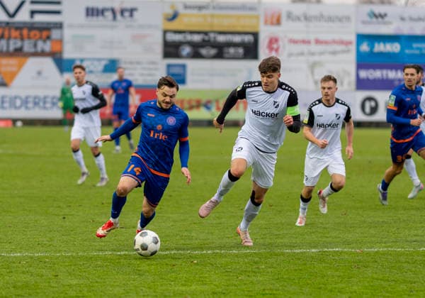 Zweikampf zwischen: Maximilian Hippe (SV Roedinghausen, 5) und Oemer Tokac (Sportfreunde Siegen, 14) SV Rödinghausen - Sportfreunde Siegen 28.11.2025 Fussball, Regionalliga West, 18. Spieltag, GER, Wiehenstadion, Rödinghausen Copyright: MarcoxBader
