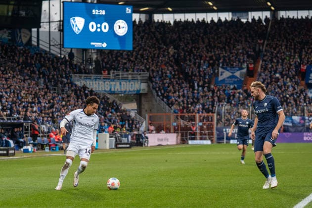 Deutschland, Fussball, 2. Bundesliga, 15.Spieltag 2025 2026: VfL Bochum - Arminia Bielefeld am 06.12. in Bochum (Vonovia-Ruhrstadion): Monju Momuluh (Arminia Bielefeld 14) Philipp Strompf (VfL Bochum 3)