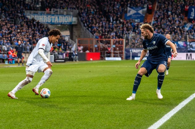 Deutschland, Fussball, 2. Bundesliga, 15.Spieltag 2025 2026: VfL Bochum - Arminia Bielefeld am 06.12. in Bochum (Vonovia-Ruhrstadion): Monju Momuluh (Arminia Bielefeld 14) Philipp Strompf (VfL Bochum 3)