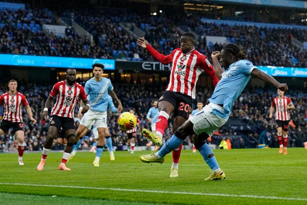 Manchester, England, 6th December 2025. Nordi Mukiele of Sunderland and Jeremy Doku of Manchester City challenge for the ball during the Manchester City vs Sunderland Premier League match at the Etihad Stadium, Manchester. Picture credit should read: Andrew Yates Sportimage EDITORIAL USE ONLY. No use with unauthorised audio, video, data, fixture lists, club league logos or live services. Online in-match use limited to 120 images, no video emulation. No use in betting, games or single club league player publications. SPI_014_AY_Man_City_Sunderland SPI-4351-0014