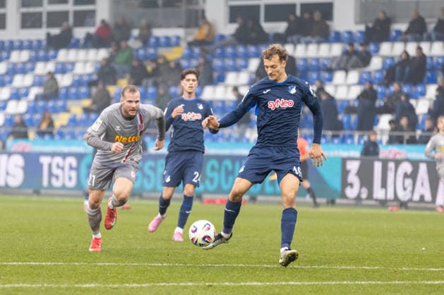 06.12.2025, Fussball, GER, Saison, 3.Liga, Saision 2025 2026, 17. Spieltag, TSG Hoffenheim II - SSV Jahn Regensburg Yannik Lührs aam Ball vor Eric Hottmann (SSV Jahn Regensburg) DFL REGULATIONS PROHIBIT ANY USE OF PHOTOGRAPHS AS IMAGE SEQUENCES AND OR QUASI-VIDEO.
