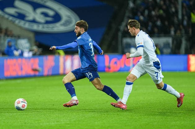 Fussball: 2. Bundesliga, 15. Spieltag, SV Darmstadt 98 - Karlsruher SC am 06.12.2025 in Darmstadt (Merck-Stadion am Böllenfalltor), Deutschland, Saison 2025 2026: DFB DFL REGULATIONS PROHIBIT ANY USE OF PHOTOGRAPHS as IMAGE SEQUENCES and or QUASI-VIDEO: Killian Julian Corredor (34, SVD) im Laufduell mit Dzenis Burnic (7, KSC). Darmstadt Merck-Stadion am Böllenfalltor Deutschland