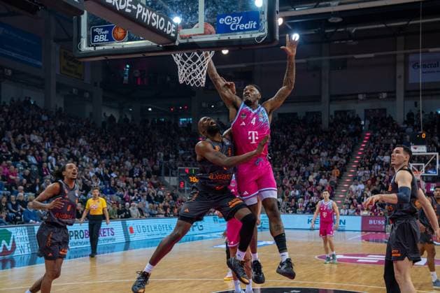 Spielszene mit Jeff Garrett Jr. (4, Telekom Baskets Bonn) und John Newman III (9, NINERS Chemnitz) unter dem Korb 91; Telekom Baskets Bonn und Kevin Yebo (0; NINERS Chemnitz) kämpfen um den Ball Copyright: xFeyzullahxGökalpx