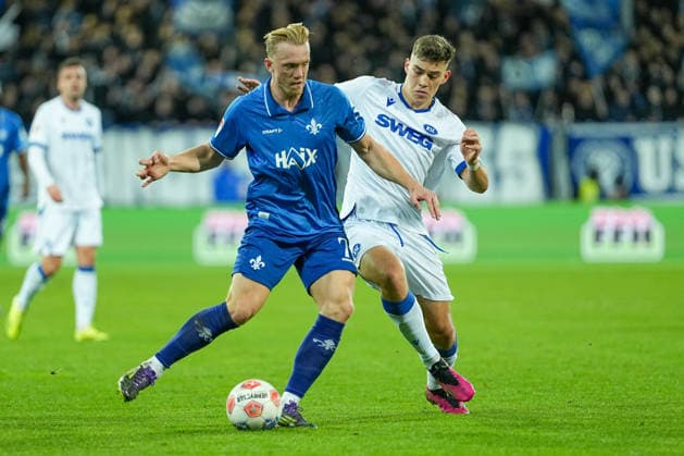 Fussball: 2. Bundesliga, 15. Spieltag, SV Darmstadt 98 - Karlsruher SC am 06.12.2025 in Darmstadt (Merck-Stadion am Böllenfalltor), Deutschland, Saison 2025 2026: DFB DFL REGULATIONS PROHIBIT ANY USE OF PHOTOGRAPHS as IMAGE SEQUENCES and or QUASI-VIDEO: Isac Alexi Sivert Lidberg (7, SVD) im Zweikampf mit Marcel Beifus (4, KSC). Darmstadt Merck-Stadion am Böllenfalltor Deutschland