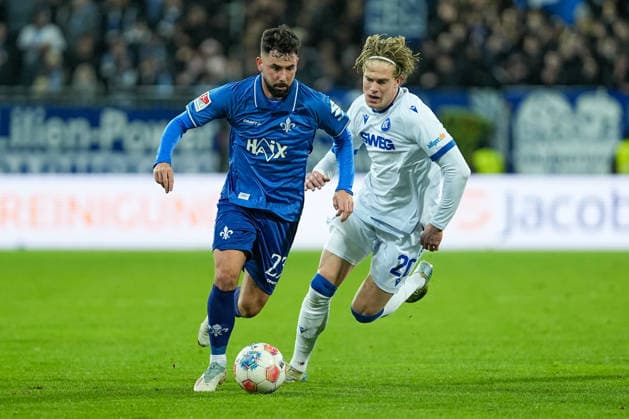 Fussball: 2. Bundesliga, 15. Spieltag, SV Darmstadt 98 - Karlsruher SC am 06.12.2025 in Darmstadt (Merck-Stadion am Böllenfalltor), Deutschland, Saison 2025 2026: DFB DFL REGULATIONS PROHIBIT ANY USE OF PHOTOGRAPHS as IMAGE SEQUENCES and or QUASI-VIDEO: Marco Richter (23, SVD) im Zweikampf mit David Herold (20, KSC). Darmstadt Merck-Stadion am Böllenfalltor Deutschland