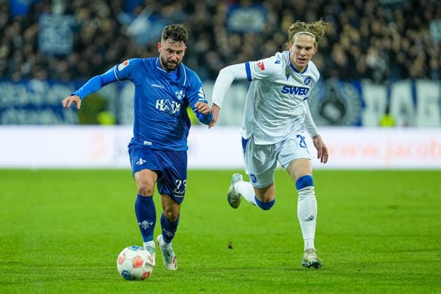 Fussball: 2. Bundesliga, 15. Spieltag, SV Darmstadt 98 - Karlsruher SC am 06.12.2025 in Darmstadt (Merck-Stadion am Böllenfalltor), Deutschland, Saison 2025 2026: DFB DFL REGULATIONS PROHIBIT ANY USE OF PHOTOGRAPHS as IMAGE SEQUENCES and or QUASI-VIDEO: Marco Richter (23, SVD) im Zweikampf mit David Herold (20, KSC). Darmstadt Merck-Stadion am Böllenfalltor Deutschland