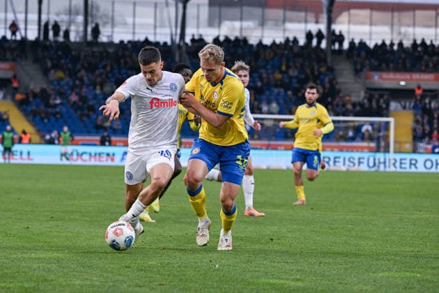 07.12.2025, Fussball, 2. Bundesliga, 15. Spieltag Saison 2025 2026, Eintracht Braunschweig - Holstein Kiel, Adrian Kapralik (Holstein Kiel) , Louis Breunig (Eintracht Braunschweig) xRHR-FOTO TKx