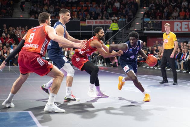 Leon Kratzer (8 Bayern) , Kresimir Nikic (9 MBC) und Thomas Khyri (0 MBC) in Aktion beim Spiel Bayern München - SYNTAINICS MBC am 07.12.2025 in München. München BMW Park Bayern Deutschland
