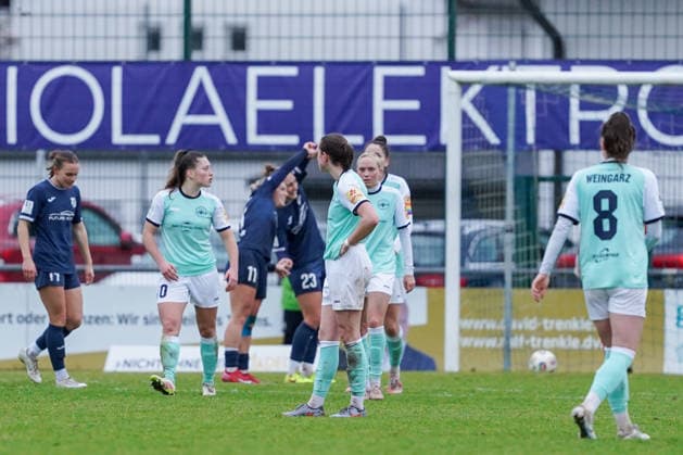 07.12.2025, Fußball, 2. Frauen-Bundesliga, 2025 2026, 12. Spieltag, SC Sand - SG 99 Andernach Und erneut ein Tor für Sand. Im Hintergrund jubeln Leni Fischer (11 Sand) und Ivana Slipcevic (23 Sand). Im Vordergrund hängen die Köpfe der Andernacherinnen.