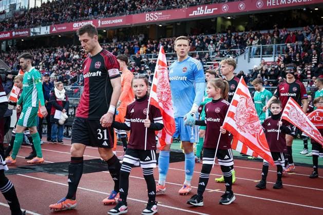 Robin Knoche 31 (1FC Nuernberg) und Jan Reichert 1 (1FC Nuernberg) fuehren die Nuernberger Mannschaft auf den Platz, 1. FC Nuernberg vs. Spvgg Greuther Fuerth, Fussball, 2. Bundesliga, DFL, Saison 2025 2026, Hinrunde, 15. Spieltag, 07.12.2025 DFB regulations prohibit any use of photographs as image sequences and or quasi-video Nuernberg Bayern Deutschland