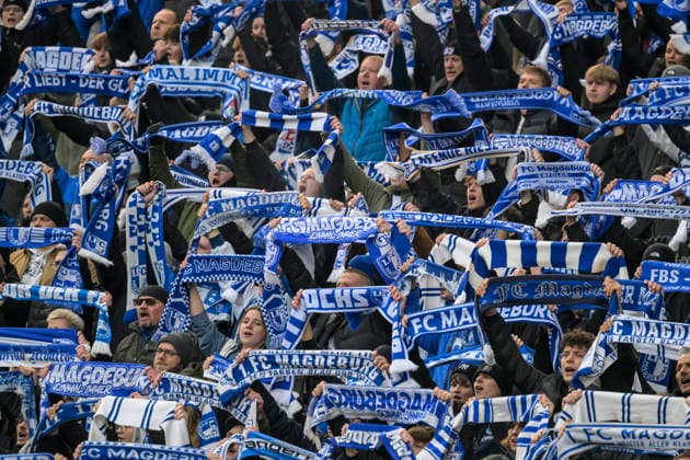 GER, Berlin, soccer, Hertha BSC vs. 1. FC Magdeburg, DFB, 2nd Bundesliga, 2025 2026 season, f.l.t.r.: fans of Magdeburg, the Magdeburg fans raise their scarves and celebrate the team. DFB DFL REGULATIONS PROHIBIT ANY USE OF PHOTOGRAPHS AS IMAGE SEQUENCES AND OR QUASI-VIDEO, December 7, 2025, Copyright: HMBxMedia UwexKoch