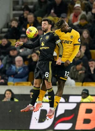 Wolverhampton, England, 8th December 2025. Bruno Fernandes of Manchester United, ManU tussles with Emmanuel Agbadou of Wolverhampton Wanderers during the Wolverhampton Wanderers vs Manchester United Premier League match at Molineux, Wolverhampton. Picture credit should read: Andrew Yates Sportimage EDITORIAL USE ONLY. No use with unauthorised audio, video, data, fixture lists, club league logos or live services. Online in-match use limited to 120 images, no video emulation. No use in betting, games or single club league player publications. SPI_082_AY_Wolves_Man_Utd SPI-4356-0084