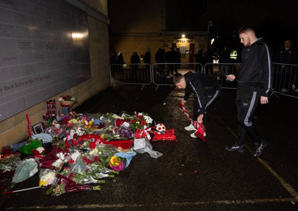 Charlton Athletic v Middlesbrough Sky Bet Championship Greg Docherty (left) and Sonny Carey of Charlton Athletic leave a scarf and plaque at the memorial outside the stadium for Norman Barker known as Headphones Norm before the Sky Bet Championship match at The Valley, London 09 12 2025 UK Newspapers OUT Copyright: xBenxPetersx FIL-22613-0049