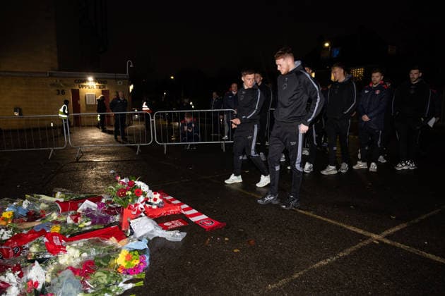 Charlton Athletic v Middlesbrough Sky Bet Championship Greg Docherty (left) and Sonny Carey of Charlton Athletic leave a scarf and plaque at the memorial outside the stadium for Norman Barker known as Headphones Norm before the Sky Bet Championship match at The Valley, London 09 12 2025 UK Newspapers OUT Copyright: xBenxPetersx FIL-22613-0051