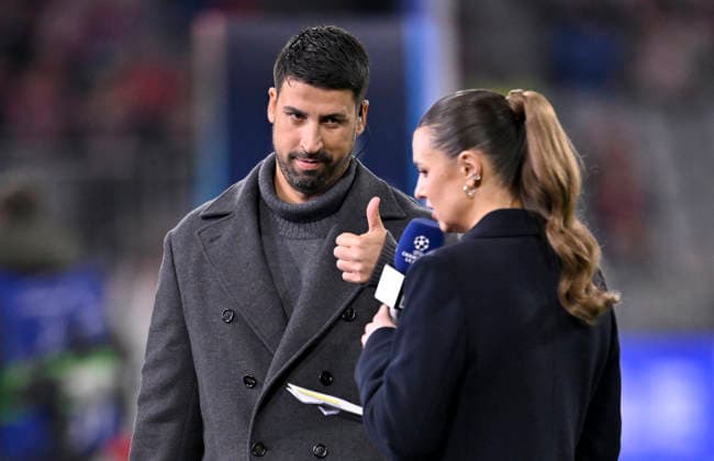 vor Spielbeginn: DAZN Moderatorin Laura Wontorra vor Interview Mikrofon Mikro Logo mit TV-Experte Sami Khedira Gestik Geste Daumen hoch FC Bayern Muenchen FCB vs Sporting Lissabon SCP Spieltag 6 09.12.2025 DFL REGULATIONS PROHIBIT ANY USE OF PHOTOGRAPHS AS IMAGE SEQUENCES AND OR QUASI-VIDEO FC Bayern Muenchen FCB vs Sporting Lissabon SCPn