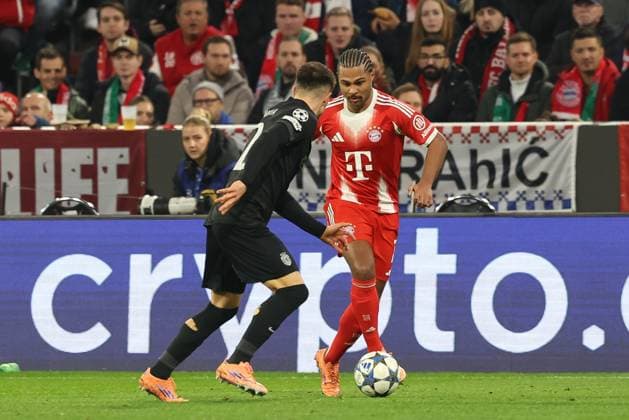 im Zweikampf, Aktion, mit Ivan Fresneda 22 (Sporting Lissabon), Serge Gnabry 7 (FC Bayern Muenchen), FC Bayern Muenchen vs. Sporting Lissabon, Fussball, Champions League, 6. Spieltag, 09.12.2025 Muenchen Bayern Deutschland