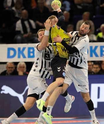 Foto : Torwurf von ..... Torben MATZGEN (Stuttgart) gegen Domagoj Duvnjak und links ... Petter Overby ( beide Kiel ) Handball Herren 1. Bundesliga am Mi. 10.12.2025 THW Kiel - TVB Stuttgart
