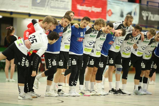 Handball, Saison 2025 2026, 3. Liga, Staffel Nord-Ost, Männer. HG Hamburg-Barmbek - EHV Aue. Die Auer Spieler stehen vor dem Anwurf Arm in Arm auf ihrer Hallenseite. Wandsbek Hamburg
