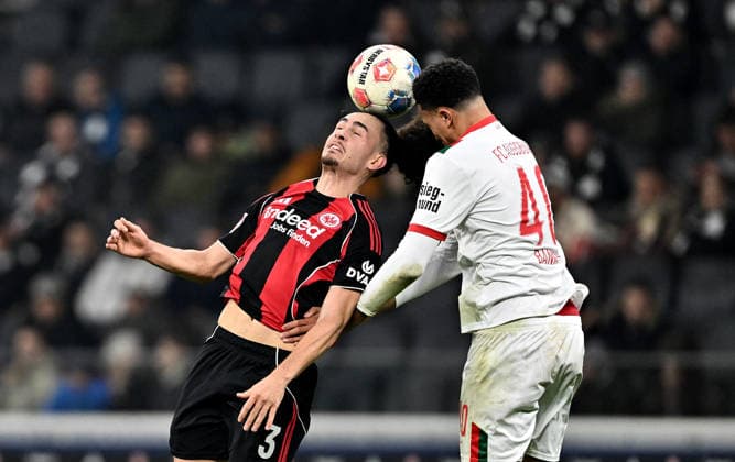 13.12.2025, xfux, Fussball 1.Bundesliga, Eintracht Frankfurt - FC Augsburg, v.l. Arthur Theate (Eintracht Frankfurt), Noahkai Dominic Banks (FC Augsburg) Kopfball, Kopfballduell (DFL DFB REGULATIONS PROHIBIT ANY USE OF PHOTOGRAPHS as IMAGE SEQUENCES and or QUASI-VIDEO) Frankfurt am Main