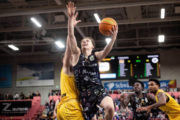 Tigers Tuebingen - Uni Baskets Muenster, Herren, 2. Bundesliga, Barmer 2. Basketball Bundesliga, pro A, 12. Spieltag, Spielzeit 2025 2026, 13.12.2025 Thore Dilschmann (Uni Baskets Muenster, 06) beim Abschluss gegen Felix Edwardsson (Tigers Tuebingen, 08)