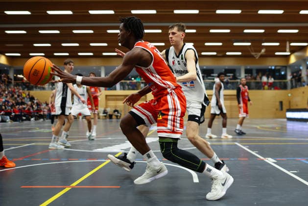 Aminu Abibu (13, TV Langen) im Hintergrund Clint Hamann (14, BG Hessing Leitershofen) beim Spiel zwischen BG Hessing Leitershofen v TV Langen, Basketball, Herren, BARMER 2.Bundesliga ProB Süd, 2025 2026, 13.Spieltag am 13.12.2025 in Augsburg, Mehrzweckhalle Stadtbergen. Bayern Deutschland