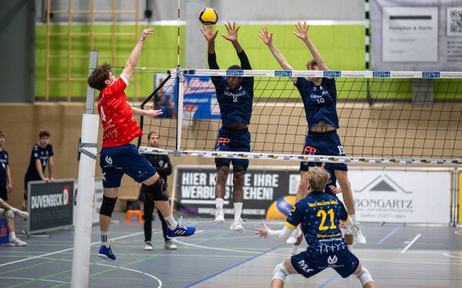 Volleyball, Saison 2025 2026, 2. Bundesliga Bord, 13.12.2025, 11. Spieltag, Herren, TuB Bocholt (blau) vs. MLK Volleys Koeln (rot) v.l.: Aaron Warneken (MLK Volleys Koeln), Rudy Schneider (TuB Bocholt), Tom Doerpinghaus (TuB Bocholt), Leo Bernsmann (Libero MLK Volleys Koeln), Bocholt Sporthalle West Nordrhein-Westfalen Deutschland