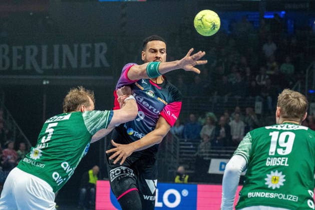 14.12.2025, xlakx, Handball Daikin HBL, Fuechse Berlin - HSG Wetzlar v.l. Max Darj (Fuechse Berlin), Philipp Ahouansou (HSG Wetzlar), Mathias Gidsel (Fuechse Berlin) Zweikampf, Duell, Kampf, tackle Berlin