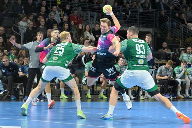 14.12.2025, xlakx, Handball Daikin HBL, Fuechse Berlin - HSG Wetzlar v.l. Matthes Langhoff (Fuechse Berlin), Justin Mueller (HSG Wetzlar), Mijajlo Marsenic (Fuechse Berlin) setzt zum Sprungwurf an Berlin