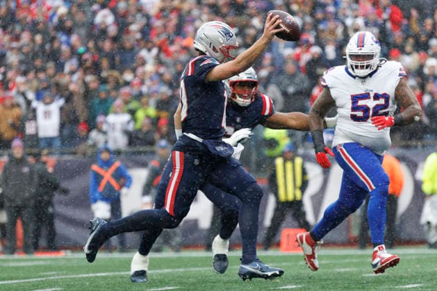 New England Patriots quarterback Drake Maye (L) avoids Buffalo Bills defensive tackle Jordan Phillips (R) as he runs in to the end zone for a touchdown during the first half at Gillette Stadium in Foxborough, Massachusetts on Sunday, December 14, 2025.  BOP20251214017 CJxGUNTHER