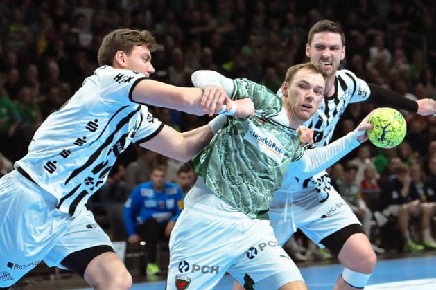 18.12.2025, xlakx, Handball DHB Pokal 1 4 Finale, Fuechse Berlin - THW Kiel v.l. Lukas Laube (THW Kiel), Mathias Gidsel (Fuechse Berlin), Hendrik Pekeler (THW Kiel) Zweikampf, Duell, Kampf, tackle Berlin