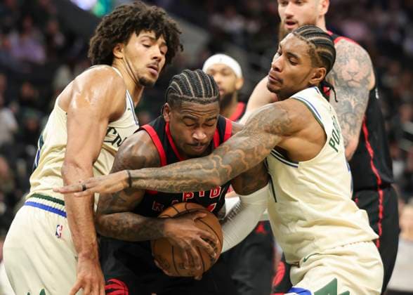 (251219) -- MILWAUKEE, Dec. 19, 2025 -- Toronto Raptors Jamal Shead (C) grabs a rebound against Milwaukee Bucks Jericho Sims (L) and Kevin Porter Jr. (R, front) during the 2025-2026 NBA, Basketball Herren, USA regular season game between Milwaukee Bucks and Toronto Raptors in Milwaukee, the United States, on Dec. 18, 2025. (Photo by Xinhua) (SP)U.S.-MILWAUKEE-BASKETBALL-NBA-BUCKS VS RAPTORS JoelxLerner 