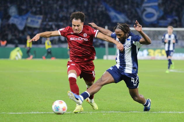 19.12.2025 Fußball Herren 2025 2026 2. Bundesliga 17. Spieltag Hertha BSC - DSC Arminia Bielefeld Olympiastadion Berlin Monju Momuluh (Arminia, 14, rot) im Zweikampf mit Deyovaisio Zeefuik (Hertha, 42, blau). Berlin Berlin Deutschland