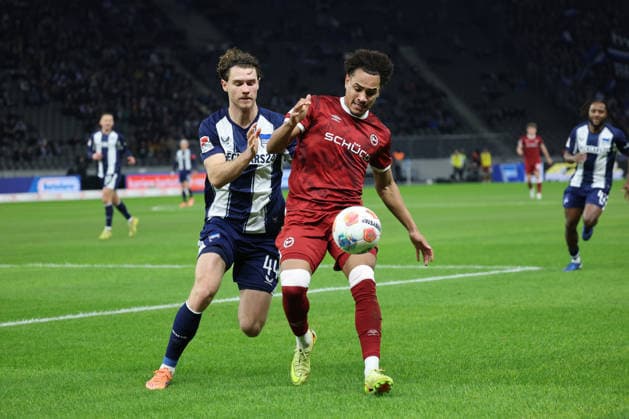 2. Fußball Bundesliga, Hertha BSC - Bielefeld; Monju Momuluh (Bielefeld, 14) im Zweikampf mit Linus Gechter (Hertha BSC 44), während der Begegnung in der 2. Fußball Bundesliga, Hertha BSC Berlin - DSC Arminia Bielefeld; 19.12.2025 in Berlin, Olympiastadion, am 19.12.2025. DFB regulations prohibit any use of photographs as image sequences and or quasi video.