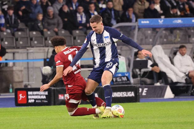 2. Fußball Bundesliga, Hertha BSC - Bielefeld; Paul Seguin (Hertha BSC 30)im Zweikampf mit Monju Momuluh (Bielefeld, 14), während der Begegnung in der 2. Fußball Bundesliga, Hertha BSC Berlin - DSC Arminia Bielefeld; 19.12.2025 in Berlin, Olympiastadion, am 19.12.2025. DFB regulations prohibit any use of photographs as image sequences and or quasi video.