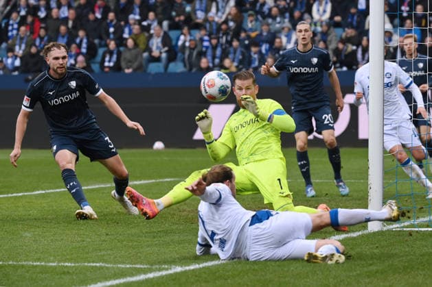 Torwart Timo Horn (VfL Bochum) in Aktion gegen Sebastian Jung (Karlsruher SC), links Philipp Strompf (VfL Bochum) 20.12.2025, Fussball 2. Bundesliga, Saison 2025 2026, 17. Spieltag, VfL Bochum - Karlsruher SC DFL regulations prohibit any use of photographs as image sequences and or quasi-video Bochum Vonovia Ruhrstadion Nordrhein Westfalen Deutschland
