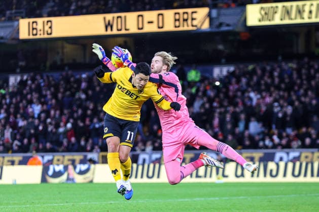 Hee Chan Hwang (11 Wolves) and Goalkeeper Caoimhin Kelleher (1 Brentford) jump for the ball during the Premier League football match between Wolverhampton Wanderers and Brentford at Molineux stadium in Wolverhampton, England Copyright: xNataliexMincher SPPx Sportspressphoto_SPR75553