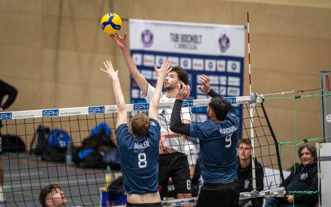 Volleyball, Saison 2025 2026, 2. Bundesliga Bord, 20.12.2025, 12. Spieltag, Herren, TuB Bocholt (weiss) vs. PSV Neustrelitz (grau) v.l.: Jannik Buehler (PSV Neustrelitz), Rudy Schneider (TuB Bocholt), Stephanos Haridimou (PSV Neustrelitz), Bocholt Sporthalle West Nordrhein-Westfalen Deutschland