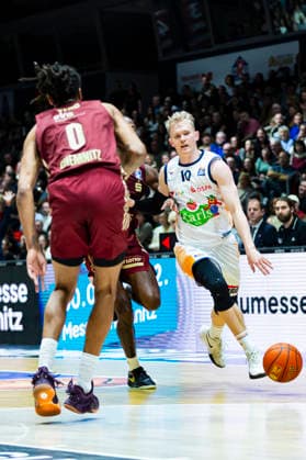 20.12.2025, xomx, Basketball easyCredit BBL Bundesliga, NINERS Chemnitz - Rostock Seawolves v.l. Lukasz Kolenda (ROSTOCK SEAWOLVES) am Ball. Kevin Yebo (Niners Chemnitz) Chemnitz