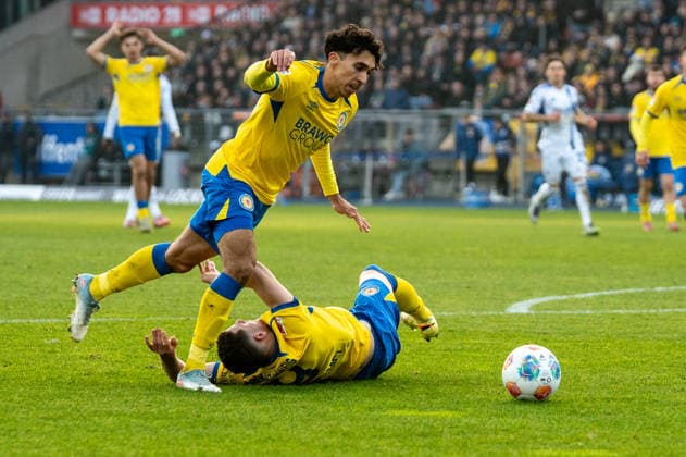 Deutschland, Fussball, 2. Bundesliga, 17.Spieltag 2025 2026: Eintracht Braunschweig - Schalke 04 am 21.12. in Braunschweig (Eintracht-Stadion): Erencan Yardimci (Eintracht Braunschweig 9) wird von Johan Gomez (Eintracht Braunschweig 44) zu Fall gebracht