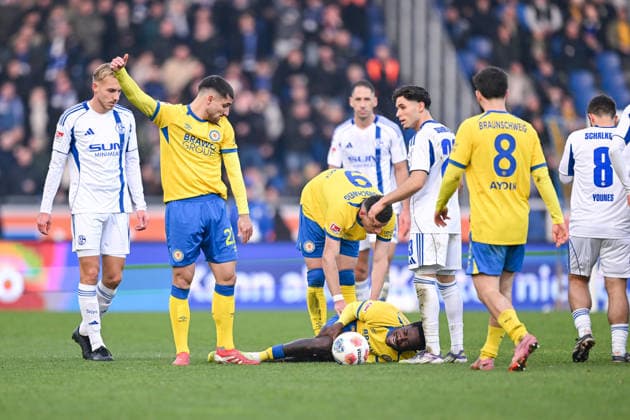 21.12.2025, Fussball, 2. Bundesliga, Saison 2025 2026, 17. Spieltag, Eintracht Braunschweig - FC Schalke 04, Joe Christian Conteh (Eintracht Braunschweig) liegt verletzt am Boden und schreit, xRHR-FOTO YYx
