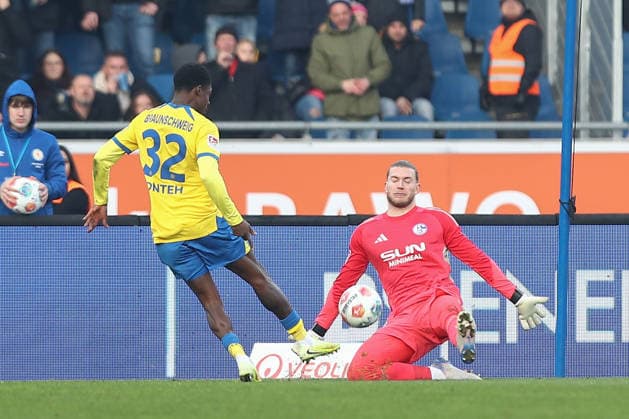 21.12.2025, xtgx, Fussball 2. Bundesliga, Eintracht Braunschweig - FC Schalke 04 v.l. Christian Conteh (Braunschweig, 32), Loris Karius (Schalke, 1) schiesst den Ball aufs Tor, Torschuss, Schuss Parade, haelt den Ball, faengt den Ball, pariert (DFL DFB REGULATIONS PROHIBIT ANY USE OF PHOTOGRAPHS as IMAGE SEQUENCES and or QUASI-VIDEO) Braunschweig