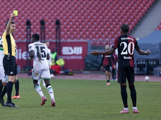 Deutschland: Fußball, 2. Bundesliga 2025 26, 17. Spieltag - 1 FC Nürnberg vs Hannover 96 - Max-Morlock Stadion (Nürnberg): Max Burda (Schiedsrichter Referee) mit der gelben Karte an Pape Demba Diop (1. FC Nürnberg, 20)