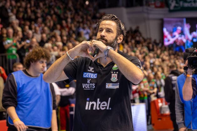 21.12.2025, xgox, Handball - Daikin HBL SC Magdeburg - SC DHfK Leipzig emspor, v.l. Bennet Wiegert (Magdeburg, Trainer) wird für 10 Jahre beim SC Magdeburg von den Fans geehert, zeigt ein Herz Magdeburg